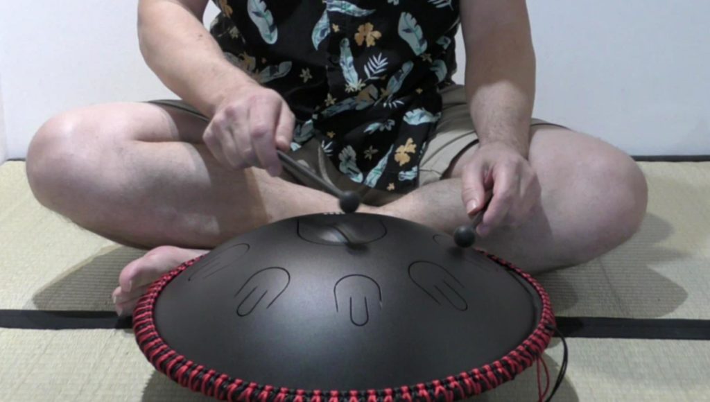 L'auteur du blog jouant d'un tongue drum Moozica avec les mailloches